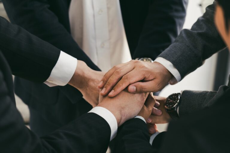 Close up of group of business people joining their hands together in unity.